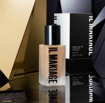 a bottle of foundation against a black and gold backdrop