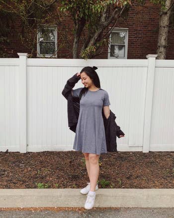 reviewer wearing the gray version with white sneakers and a knitted chunky cardigan