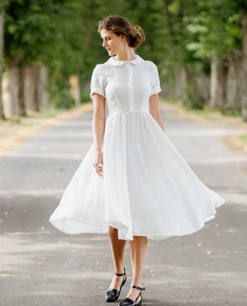 model wearing the white dress buttoned up