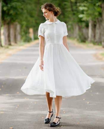 model wearing the white dress buttoned up