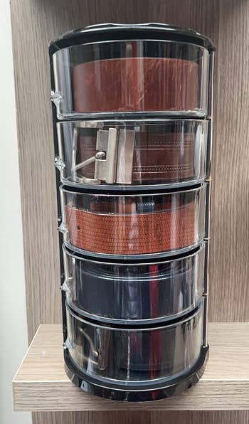 reviewer's acrylic belt organizer with five belts in it