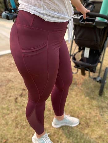 another reviewer showing the mesh detailing on the side of their burgundy leggings