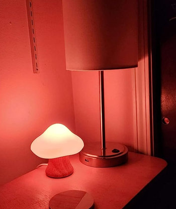 the little mushroom lamp glowing on a nightstand