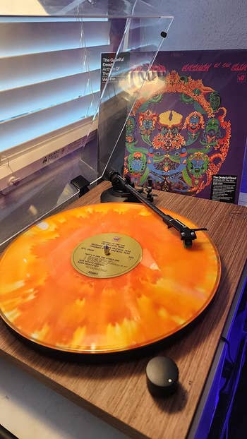 an orange marbled record on a white turntable mat
