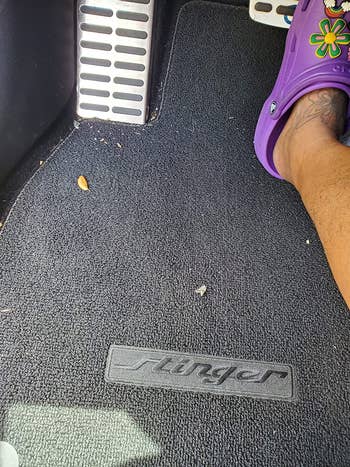 reviewer's car pedals and carpet before with leaves and crumbs