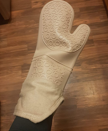 reviewer wearing the tan oven mitt