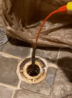 gif of reviewer pulling a long clump of hair out of a drain using the flexisnake