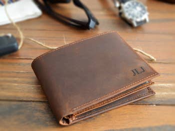 front of brown leather wallet with engraved initials in bottom right corner