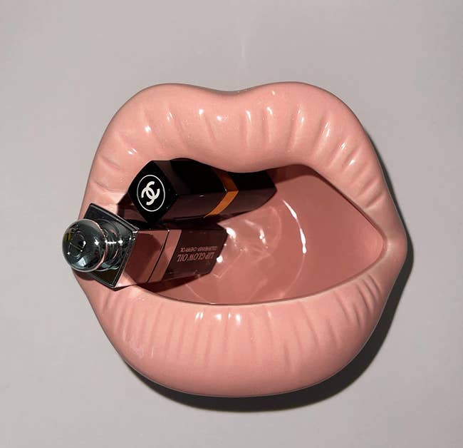 reviewers light pink ceramic lips dish with a couple lipstick tubes in it 