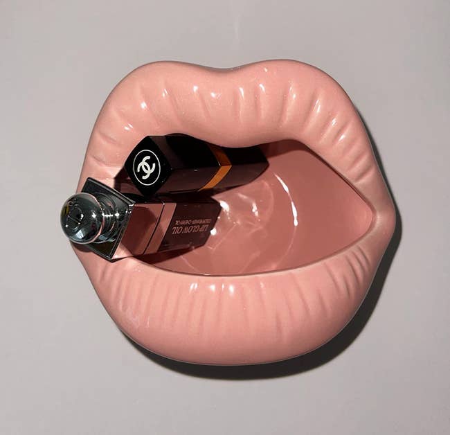 reviewers light pink ceramic lips dish with a couple lipstick tubes in it 