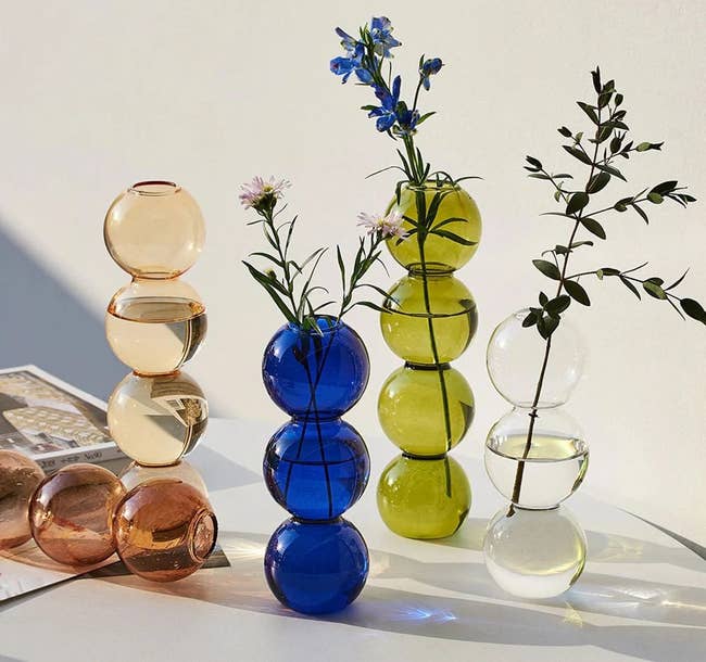 multiple tall vases made of three and four bubbles with one to two stems inside 