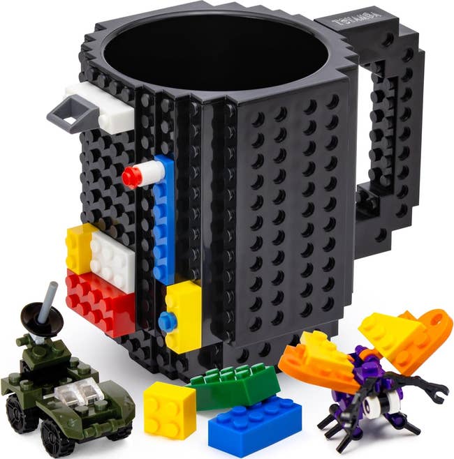 the black build-on brick mug with buildable bricks next to it