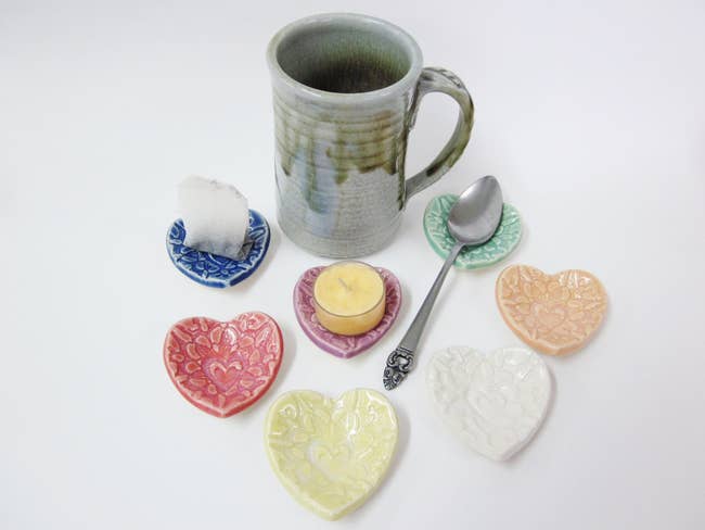 Heart shaped clay spoon rests in different colors with heart patterns carved into them 