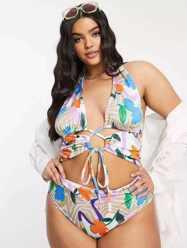 model showing the cut out swimsuit with a white cover up
