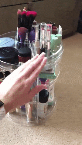 Reviewer spinning the clear acrylic organizer full of products 