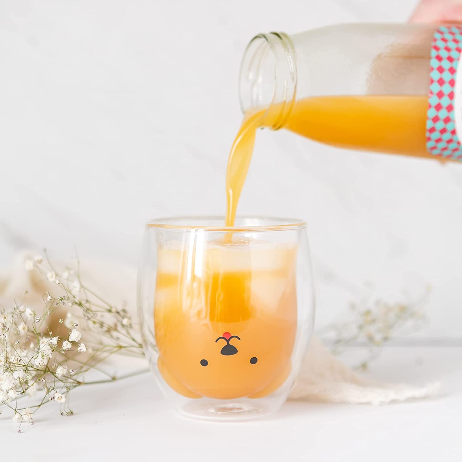 orange juice poured into glass with inner glass shaped like dog