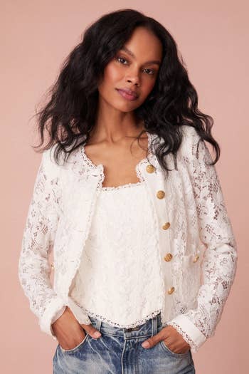 model in collarless white lace jacket with gold buttons