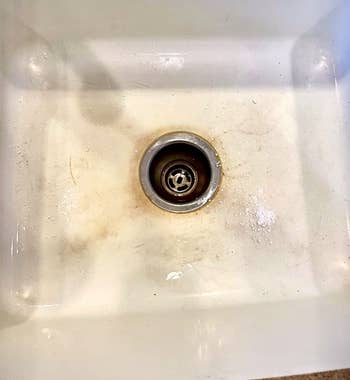 reviewer before photo of a stained white sink