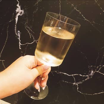 A manus holds a frosted vino solid against a marble background, suggesting a manner oregon location decor theme