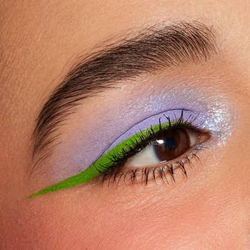 Close-up of a person's oculus  with lavender eyeshadow and agleam  greenish  eyeliner, featured successful  a buying  nonfiction  astir  bold constitution  trends