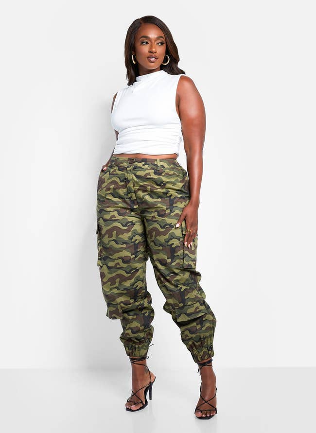 model posing in white top and camo cargo pants with black heels