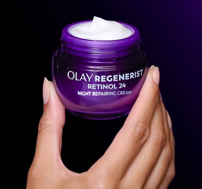 Hand holding a jar of Olay Regenerist Retinol 24 Night Repairing Cream with substance asking if it fades acheronian spots