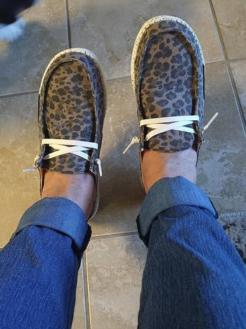 a reviewer wearing the shoes featuring an aanimal print 
