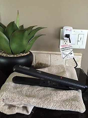 Straightener plugged in to the auto shut off attachment for the outlet