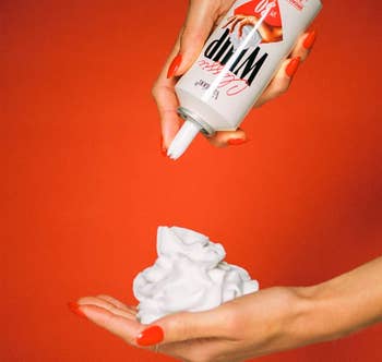 Person dispensing whipped pick  onto their manus  from a tin  labeled 