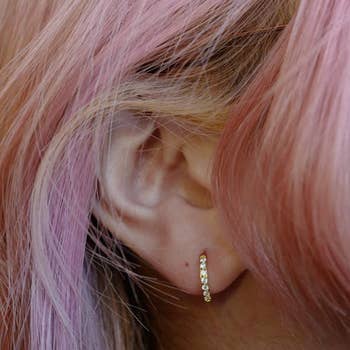 a model wearing a jeweled hoop earring