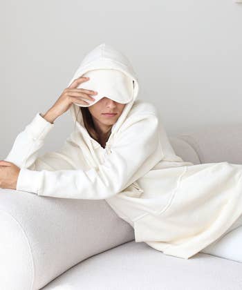model in cream hoodie with built-in sleep mask