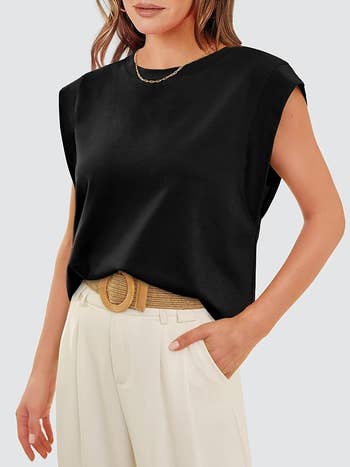 model wearing a sleeveless achromatic  apical  and achromatic  pants with a woven belt, styled casually; suitable for a buying  article