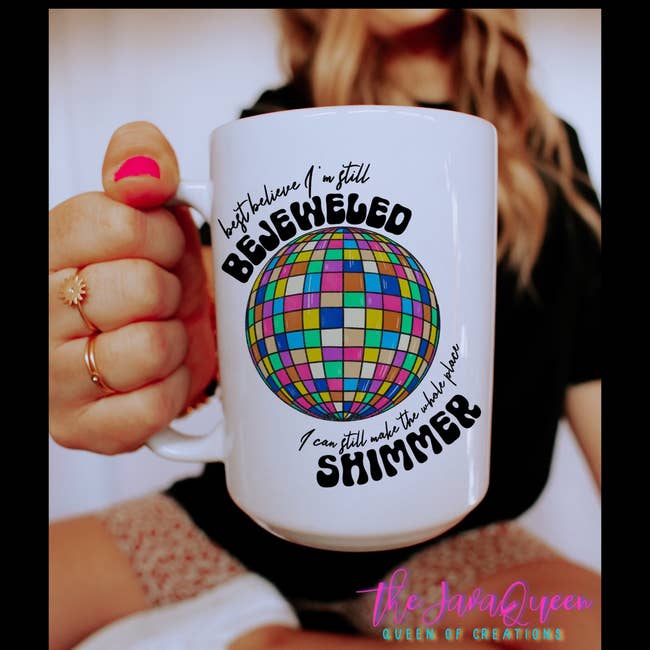 a model holding up the bejeweled mug