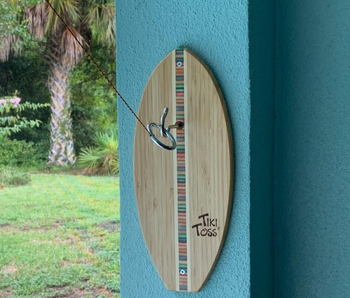 reviewer photo of the Tiki Toss game mounted to wall outside