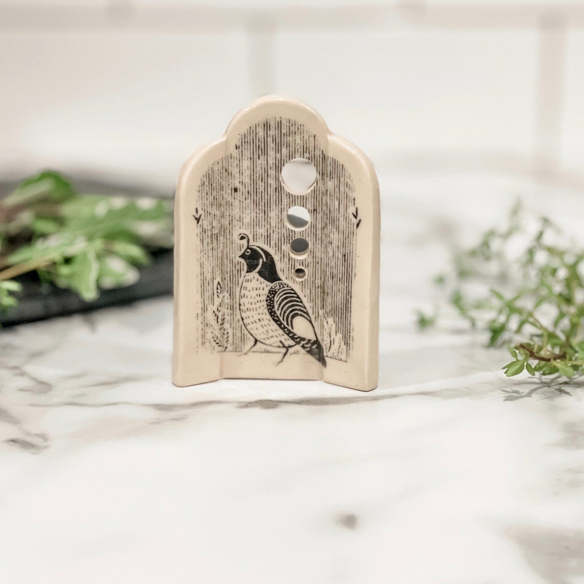 ceramic tag-shaped device with painting of a quail and four holes
