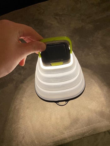 reviewer photo of them holding the lit, fully extended light
