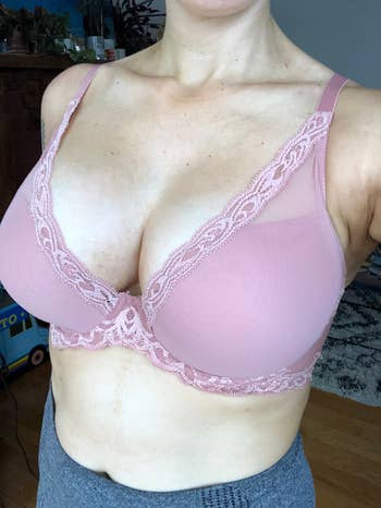 Person modeling a lace-trimmed bra successful a casual indoor setting