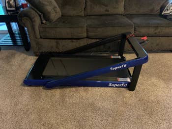 reviewer photo of their blue and black treadmill folded semi-down