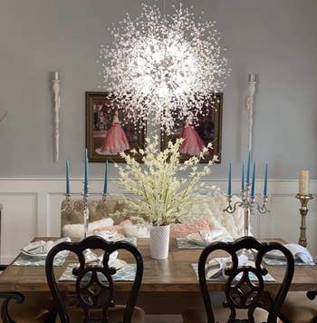 dining room with the chandelier glowing a cool light above the table