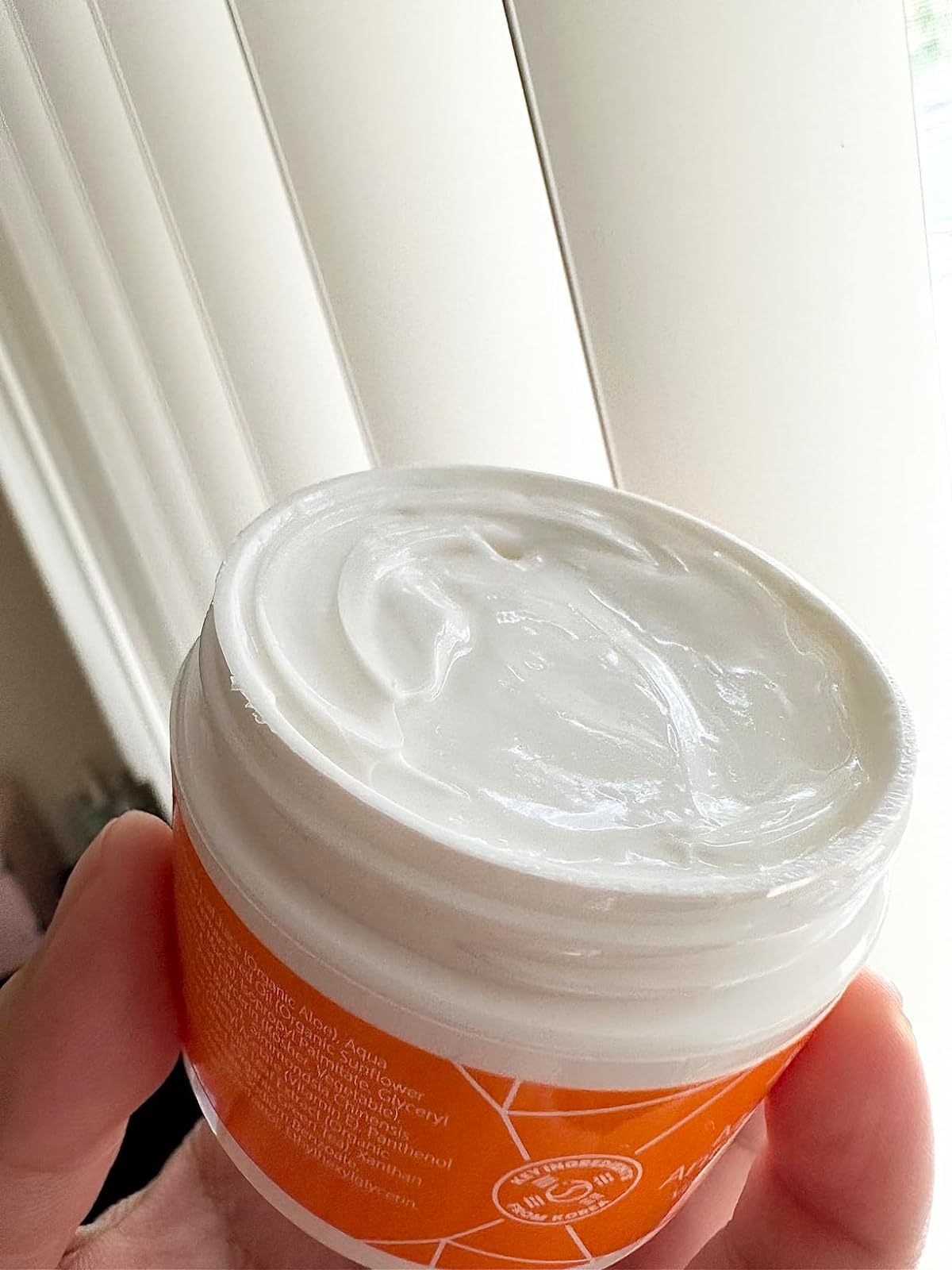 the open tub of cream 