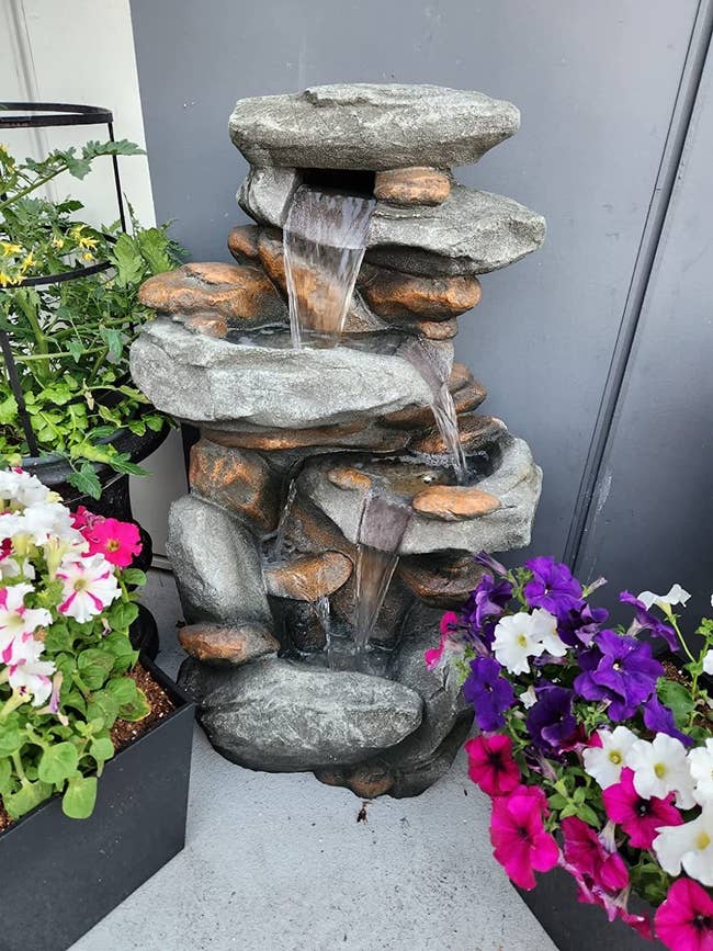 reviewer image of the stone waterfall fountain in a garden