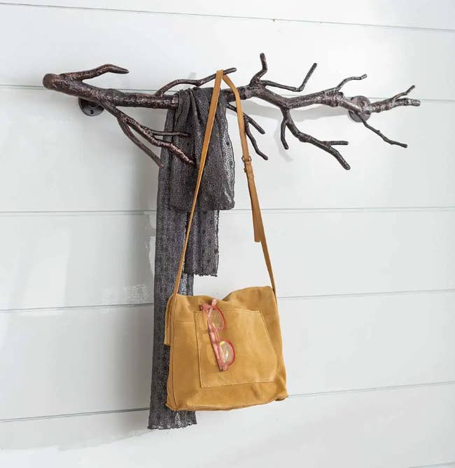 Image of the brown branch coat rack holding a yellow purse and glasses