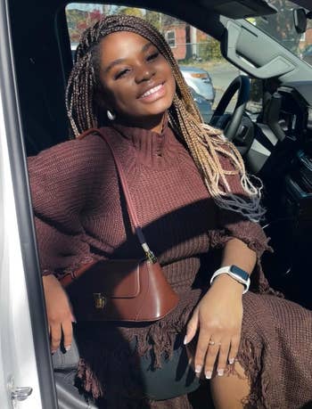 Person successful  a knit formal  with a handbag and smartwatch, smiling portion    sitting successful  a vehicle