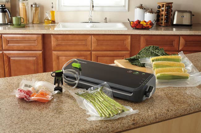 A black vacuum sealer with a food that is sealed