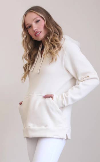 model wearing the cream-colored hoodie