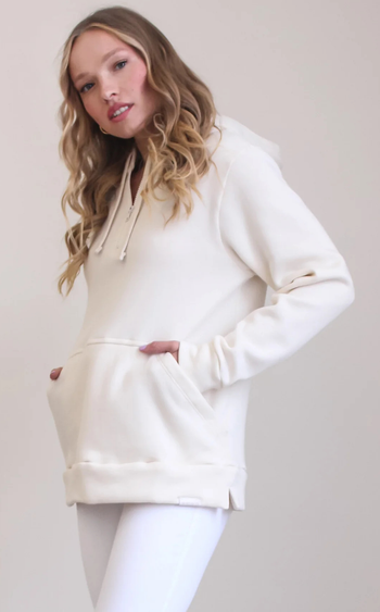model wearing the cream-colored hoodie