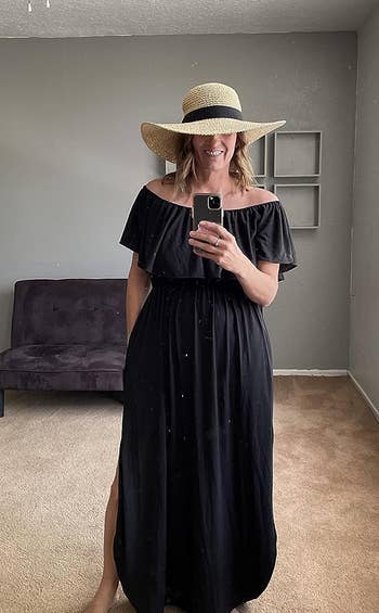 reviewer wearing the black dress and a straw hat