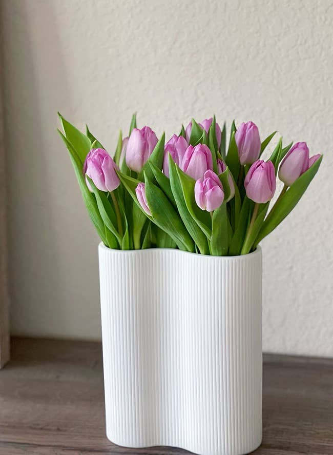 white infinity-shaped vase holding a reviewer's tulips