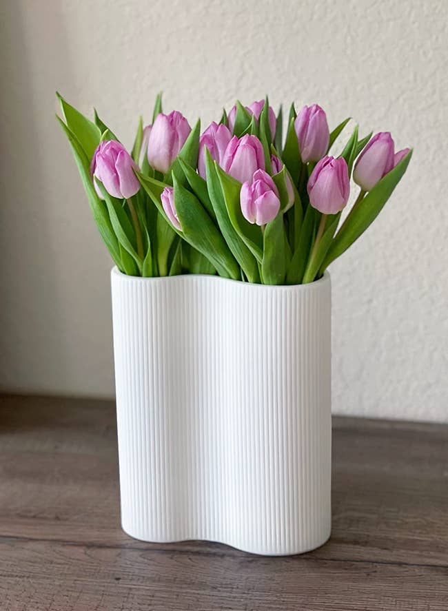 white infinity-shaped vase holding a reviewer's tulips