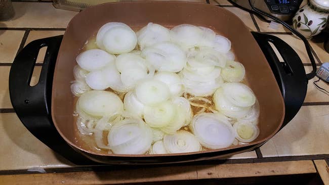 A reviewer's pan filled with onions